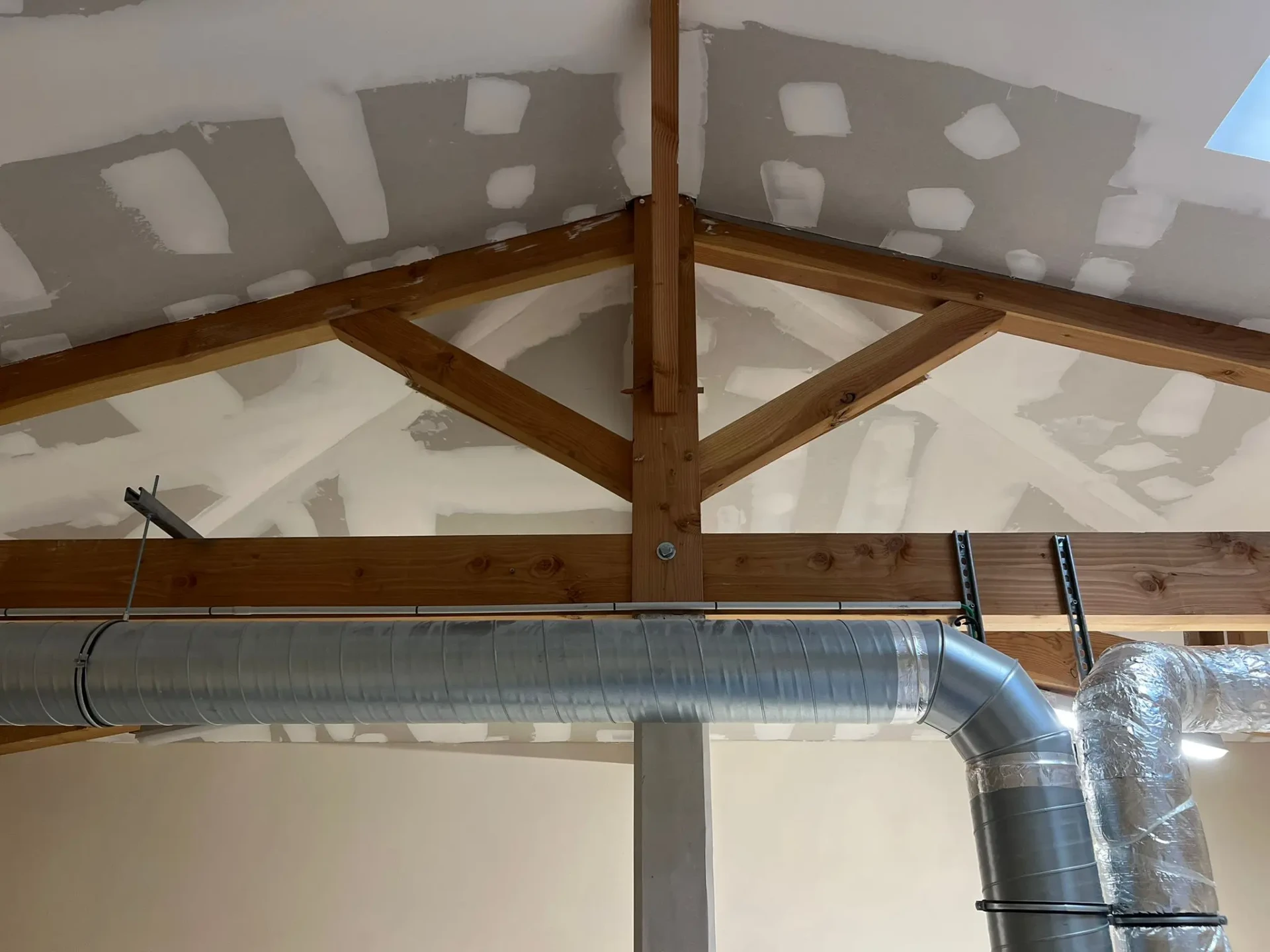 Plafond en placo avec charpente bois apparente en cours de rénovation à Bordeaux